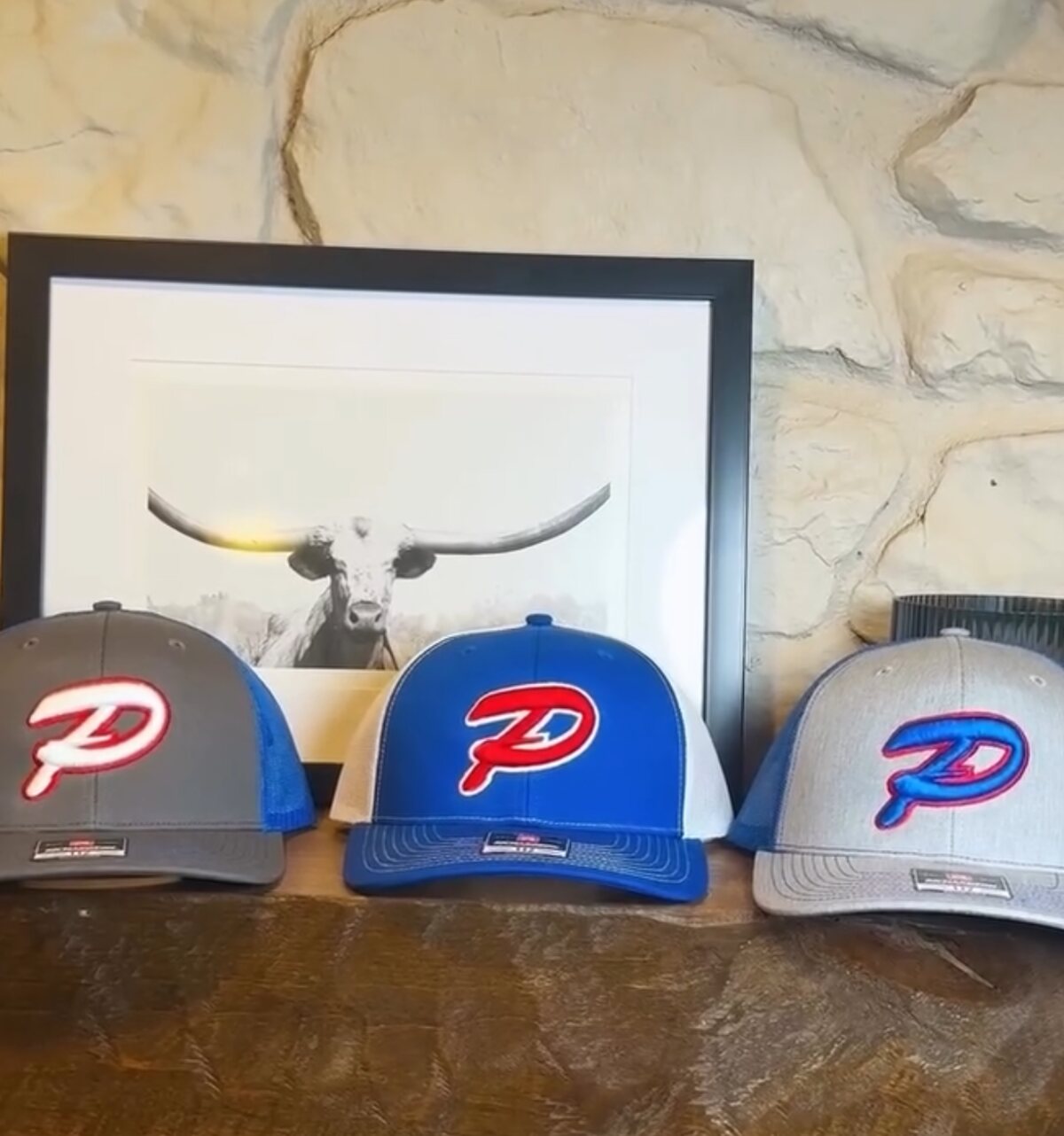 Three trucker caps in gray, blue and white, each with a P monogram