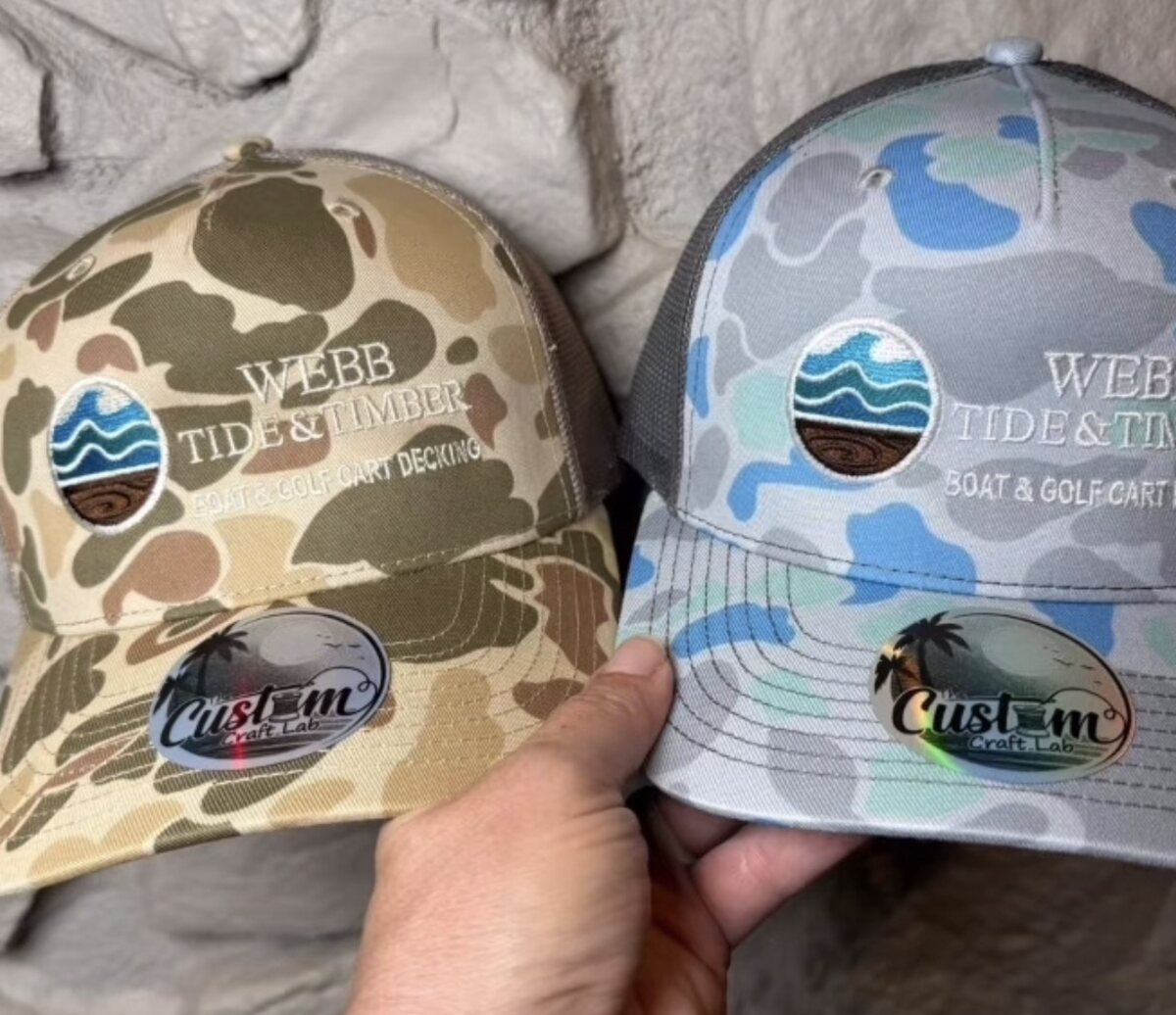 Two camo trucker caps embroidered with the Webb Tide and Timber patch logo