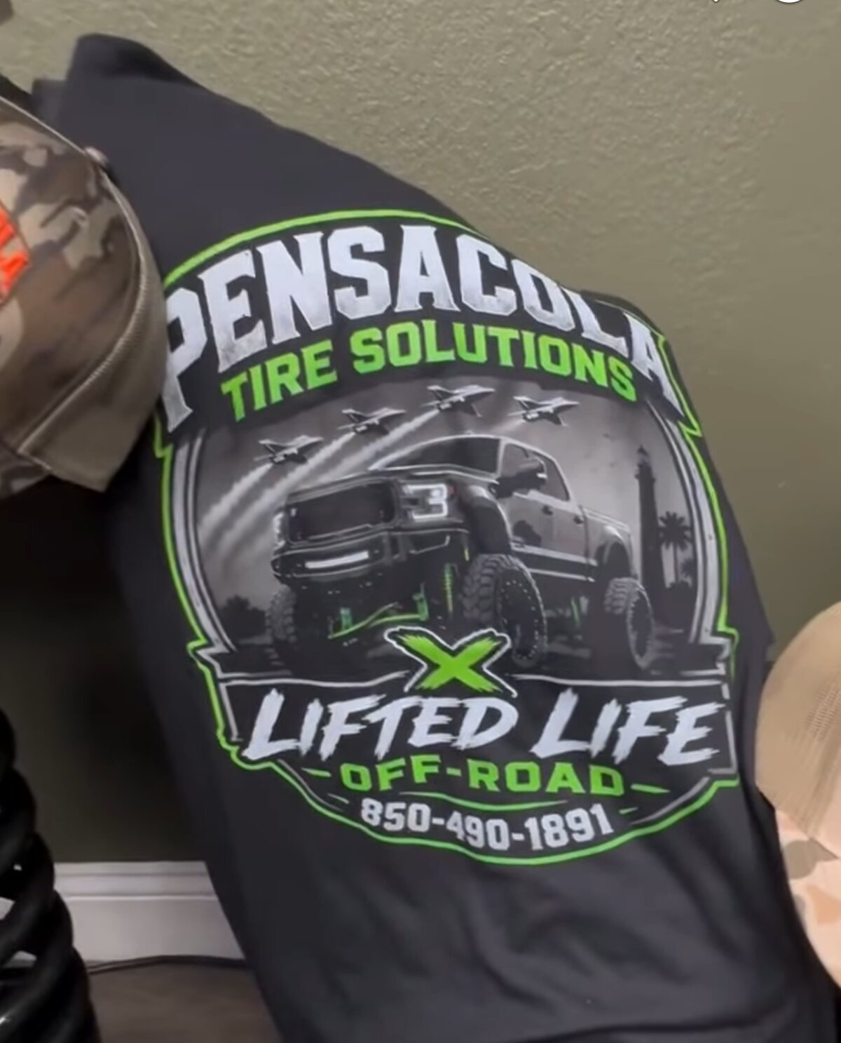 Black t-shirt printed with the Pensacola Tire Solutions and Lifted Life Off-Road logo